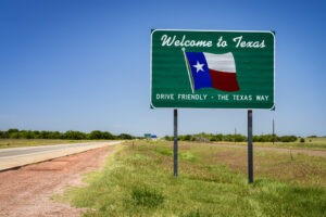 A highway sign welcoming people to Texas and encouraging them to drive friendly so they won’t have to hire an Irving personal injury lawyer.